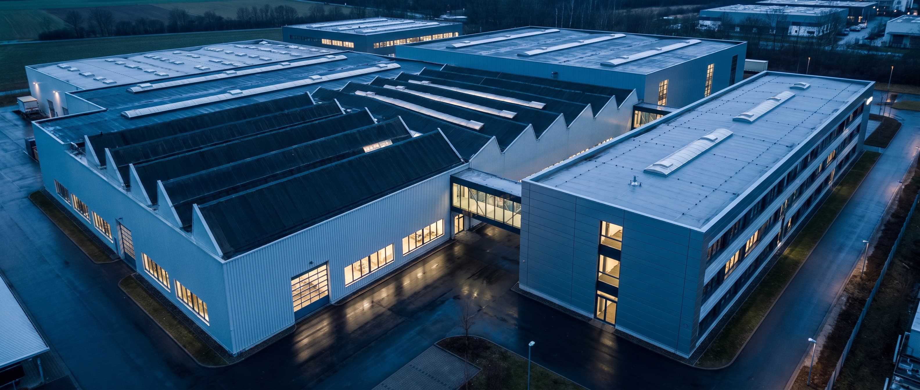 Industriecampus zur blauen Stunde, eine neue Halle dockt an den Bestand an